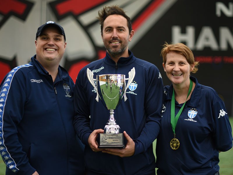 South Melbourne FC Team Manager Skip Fulton, Coach : Igor Negrao and Goal Guide Bess Hepworth holding the trophy for winning the National Blind Football Series